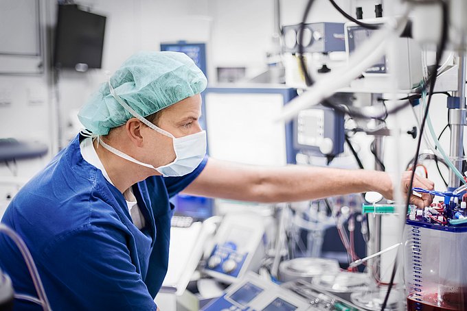 Dies ist ein Kardiotechniker, der Einstellungen an einer Herz-Lungen-Maschine vornimmt.