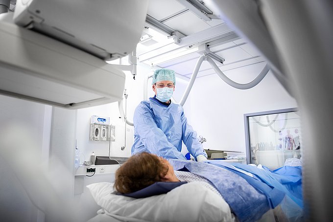 Dies ist ein Patient, der von einem Radiologen in einen Computertomografen geschoben wird.