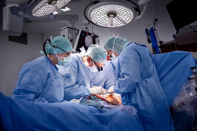 Dies zeigt Chirurgen bei einer Herzoperation in einem OP-Saal.