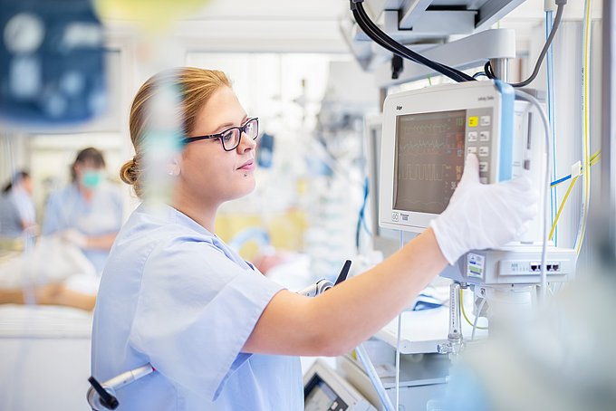 Dies ist Pflegerin bei der Bediening eines medizinischen Gerätes.