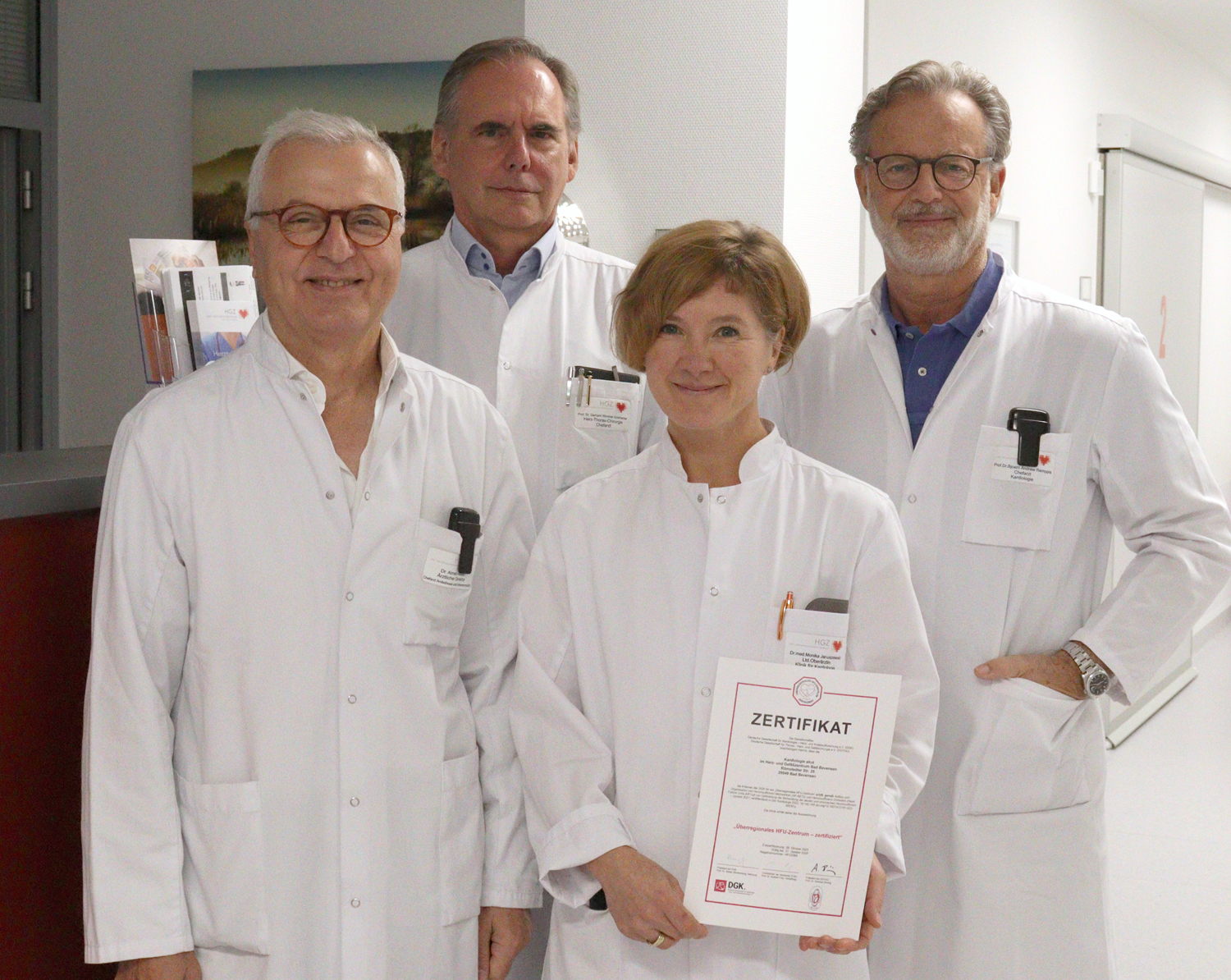 Vier Personen - eine Ärztin und drei Ärzte - präsentieren ein Zertifikat.